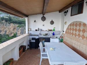 un patio con tavolo e sedie bianchi e bancone di Estate4home - MAISON LIRIO a Positano