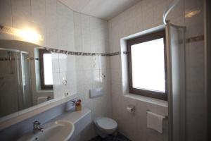 トゥクスにあるLandhaus Tuxerschaferのバスルーム(洗面台、トイレ、鏡付)