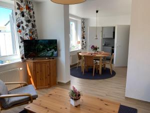 ein Wohnzimmer mit einem TV und einem Esstisch in der Unterkunft Zinnowitz Haus Zur Duene Wohnung 14 W14ZDL in Zinnowitz