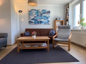 ein Wohnzimmer mit einer Couch und einem Sessel in der Unterkunft Zinnowitz Haus Zur Duene Wohnung 14 W14ZDL in Zinnowitz