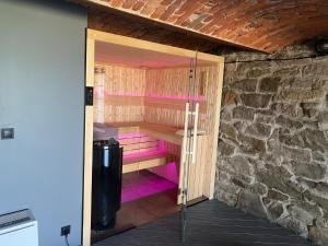 een sauna met roze verlichting in een stenen muur bij 120 letnia Chata w Górach z jacuzzi i sauną 