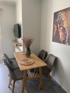 tavolo da pranzo con due sedie e un vaso sopra di Lefkada Town Apartment a Città di Lefkada