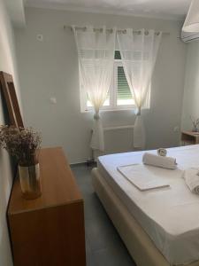 una camera con letto e finestra con tende di Lefkada Town Apartment a Città di Lefkada