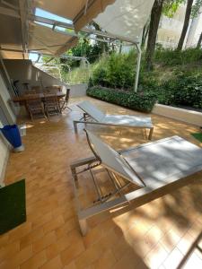 a patio with two lounge chairs and an umbrella at Casa Roberta con favolosa terrazza privata in Caorle