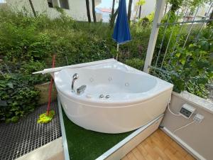 una vasca da bagno seduta su un patio con ombrellone di Casa Roberta con favolosa terrazza privata a Caorle