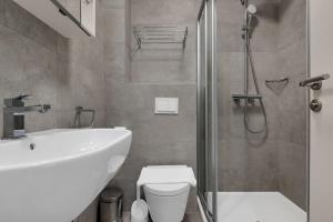 uma casa de banho com um lavatório, um chuveiro e um WC. em Brotis - StudioApartment em Promajna