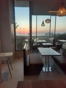 een restaurant met tafels en stoelen en uitzicht op de stad bij Asilah Marina Golf Appart in Asilah