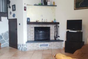 a living room with a brick fireplace with a tv at casa vacanze “Tra cielo e mare” Agerola in Agerola +4 photos