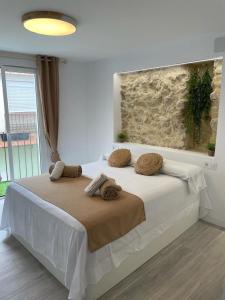 Un dormitorio con una gran cama blanca con almohadas. en Ereta Rooms Habitaciones baño privado, en Alicante