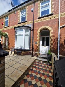 a brick house with a patio in front of it at Hidden Beauty! 5 Bedroom House near town centre with Bike Store in Merthyr Tydfil
