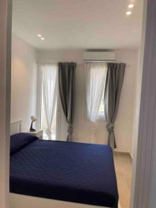 una camera con un letto blu e una finestra di Stupendo Appartamento sulla spiaggia ad Alcamo