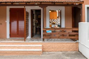 un porche delantero de una casa con puerta roja en Studio De Bosset en Argostoli