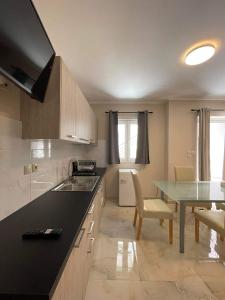 a kitchen with a black counter top and a table at ALLAGIANNIS GROUP APARTMENTS in Markopoulo