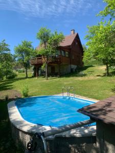a swimming pool in front of a house at Chata s bazénem Bozkov in Bozkovska