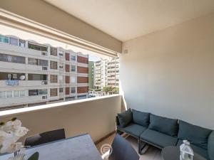 ein Wohnzimmer mit einem Sofa und einem großen Fenster in der Unterkunft Zaffiro Apartment in Quartu SantʼElena