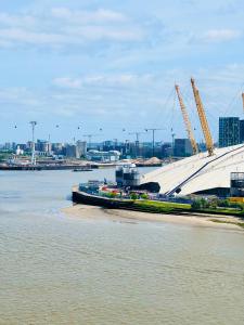a large white building next to a body of water at Canary Wharf, E14 9PW, 2 Bedroom Apartment in London