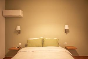 a bedroom with a bed with two night stands and two lamps at Twin House Spetses in Spetses