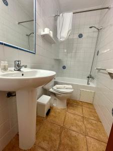 a white bathroom with a sink and a toilet at AT Espalmador Formentera rustick in Es Pujols