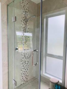 a shower with a glass door in a bathroom at Besties West Auckland in Kumeu