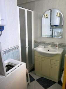 W łazience znajduje się umywalka i lustro. w obiekcie Oasis junto al mar w mieście Torre del Mar