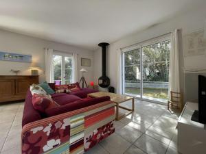 salon z fioletową kanapą i dużym oknem w obiekcie Villa bord de mer, 10 pers, 5 chbres, proche plage, jardin privé, Wifi, animaux ok - FR-1-246A-207 w mieście Saint-Georges-dʼOléron