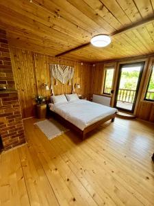 a bedroom with a bed in a wooden room at House Girska Rika in Korchin