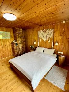 una camera da letto con un grande letto in una camera in legno di House Girska Rika a Korchin
