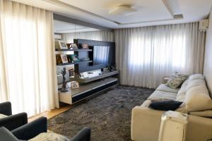 a living room with a couch and a flat screen tv at Casa Garavaglia in Bento Gonçalves
