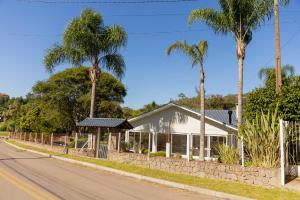 a house on the side of a road with palm trees at Casa Garavaglia in Bento Gonçalves