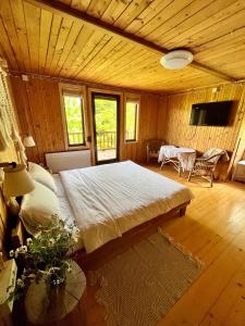 ein Schlafzimmer mit einem großen Bett in einem Holzzimmer in der Unterkunft House Girska Rika in Korchin