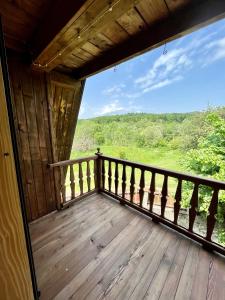 a balcony of a cabin with a view of the woods at House Girska Rika in Korchin