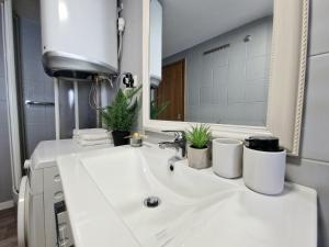 a bathroom with a white sink and a mirror at Promenada Apartment in Srima