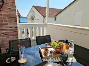 a table with a bowl of fruit on a balcony at Promenada Apartment in Srima