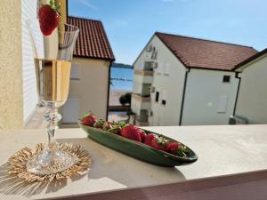 a bowl of strawberries and a glass of champagne on a table at Promenada Apartment in Srima +28 photos