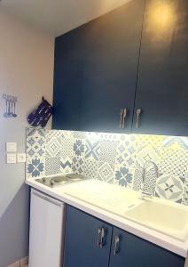 una cocina con armarios azules y fregadero en SUPERBE STUDIO VUE MER - Plage, Piscine ET Tennis Prive, en Bandol