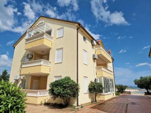 an apartment building with balconies and a blue sky at Promenada Apartment in Srima