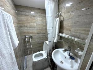 une salle de bain avec des toilettes blanches et un lavabo dans l'établissement Apartments on Buzand street, à Erevan