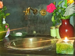 a sink with a candle and flowers on a counter at Riad Karmanda in Marrakech