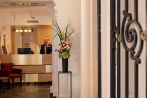 a lobby with a vase of flowers on a table at Palym in Paris