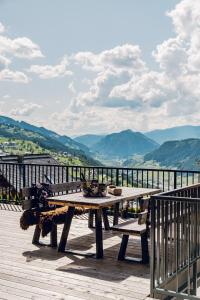 una mesa de picnic en una terraza con vistas a las montañas en Chalet W - auf der Planai -zu jeder Jahreszeit, en Schladming