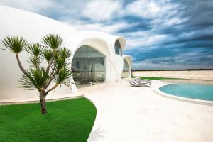 タバナンにあるThe Cloud Beachfront Villa Tabananのヤシの木とスイミングプールのある白い家 +36枚の写真