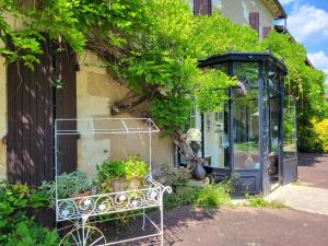 une cabine téléphonique avec des plantes sur le côté d'un bâtiment dans l'établissement Hôtel La Flambée, à Bergerac