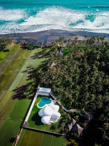 una vista aérea de un complejo con piscina y océano en The Cloud Beachfront Villa Tabanan en Tabanan