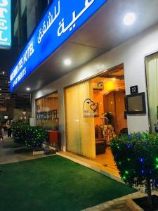 un negozio con un prato verde davanti di PAN EMIRATES HOTEL APARTMENTS a Sharjah