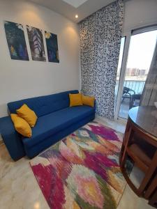 a living room with a blue couch and a table at Two Bedrooms for Families only Chalet Sia Lagoon Golf Porto Marina للعائلات فقط شاليه غرفتين كريستال لاجون جولف بورتو مارينا in El Alamein