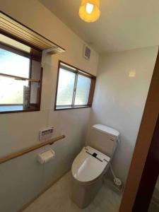 een badkamer met een toilet en een raam bij オオヤシロSTAY旅音 in Izumo