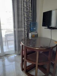 a table with a television and a chair in a room at Two Bedrooms for Families only Chalet Sia Lagoon Golf Porto Marina للعائلات فقط شاليه غرفتين كريستال لاجون جولف بورتو مارينا in El Alamein