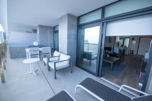 a balcony with a couch and a table and chairs at Apartment Sunset Cliffs Poniente in Benidorm