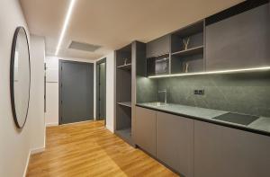 uma cozinha com armários pretos e piso em madeira em Rentalmar Suites Salou Families Only em Salou