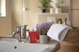 a bathroom sink with a towel and flowers on it at L'Eldorado - Tout confort in Strasbourg